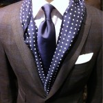 A bright polka dot scarf with a dark suit